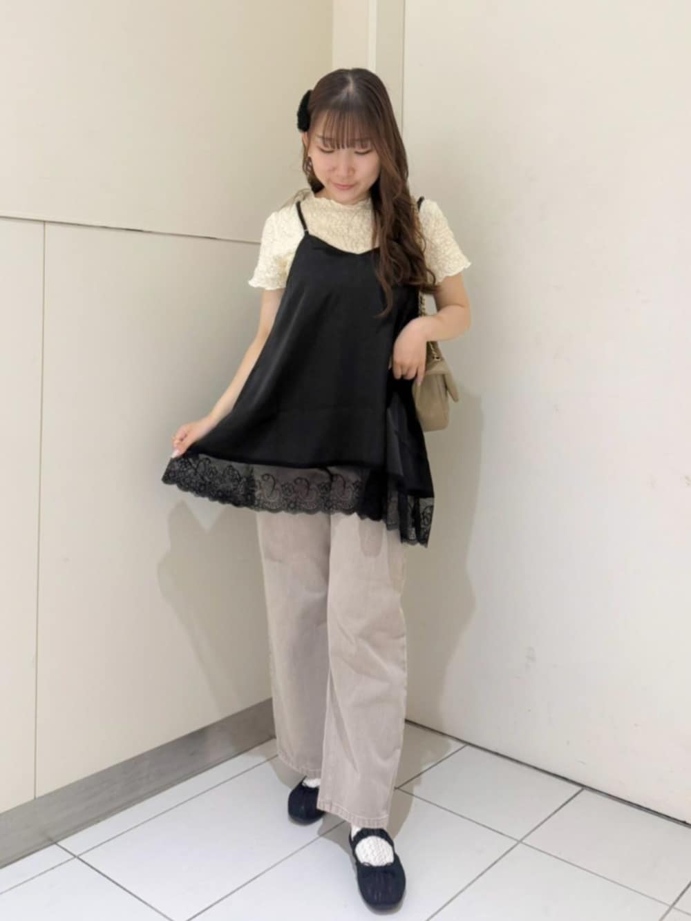 ベージュ系のショルダーバッグ、ホワイト系のTシャツ/カットソー、ブラック系のキャミソールを着用したレディースの夏コーディネートの1枚目の写真