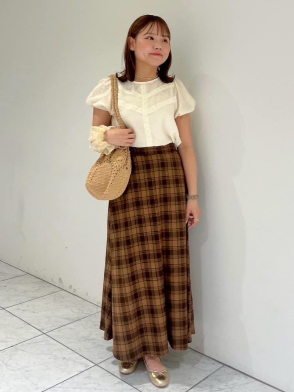 ブラウン系のショルダーバッグ、ホワイト系のシャツ/ブラウス、ブラウン系のスカートを着用したレディースの秋コーディネートの1枚目の写真