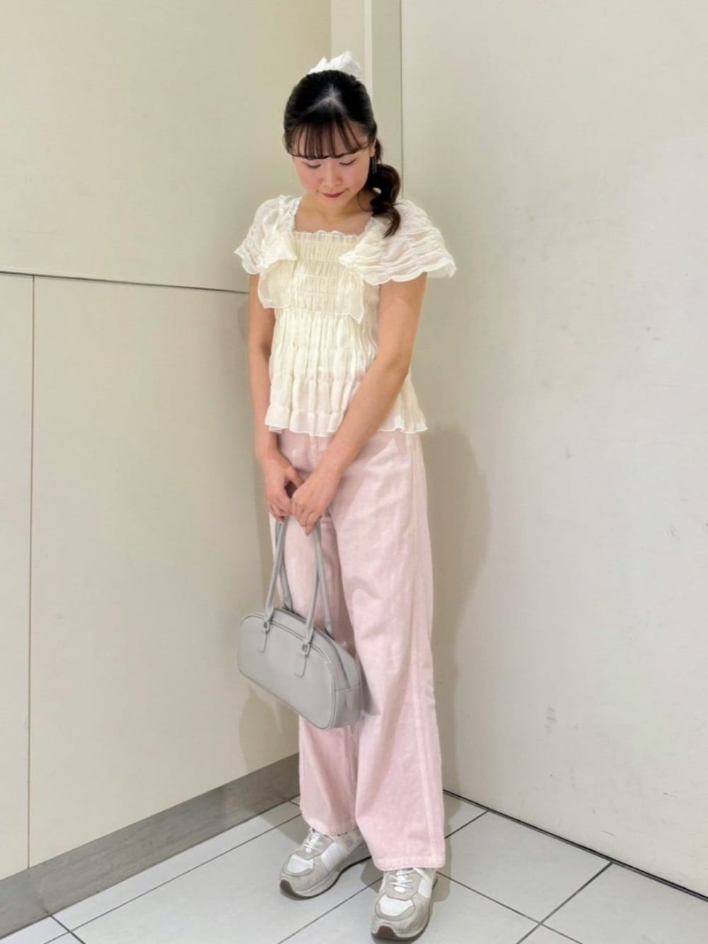 ピンク系のデニムパンツ、ホワイト系のシャツ/ブラウス、グレー系のショルダーバッグを着用したレディースの夏コーディネートの1枚目の写真