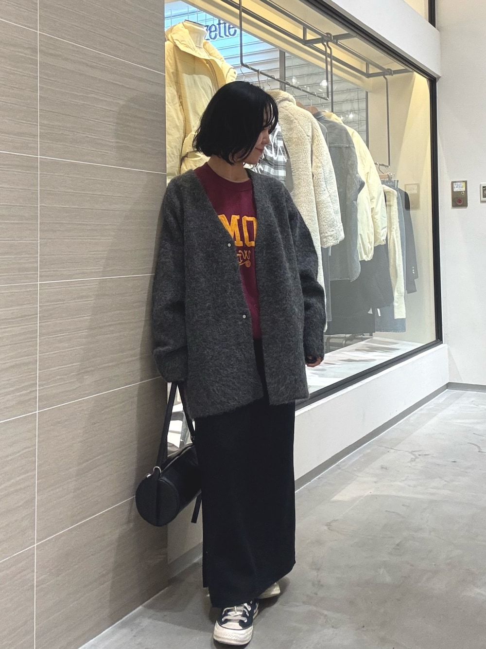 グレー系のその他アウター、ブラック系のショルダーバッグ、ブラック系のスカートを着用したレディースの秋コーディネートの1枚目の写真