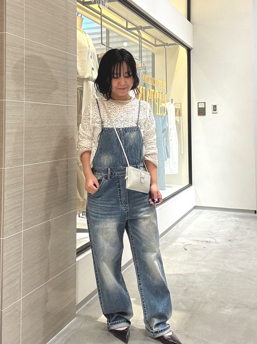 ブルー系のつなぎ/オールインワン、ホワイト系のシャツ/ブラウス、グレー系のショルダーバッグを着用したレディースの冬コーディネートの1枚目の写真