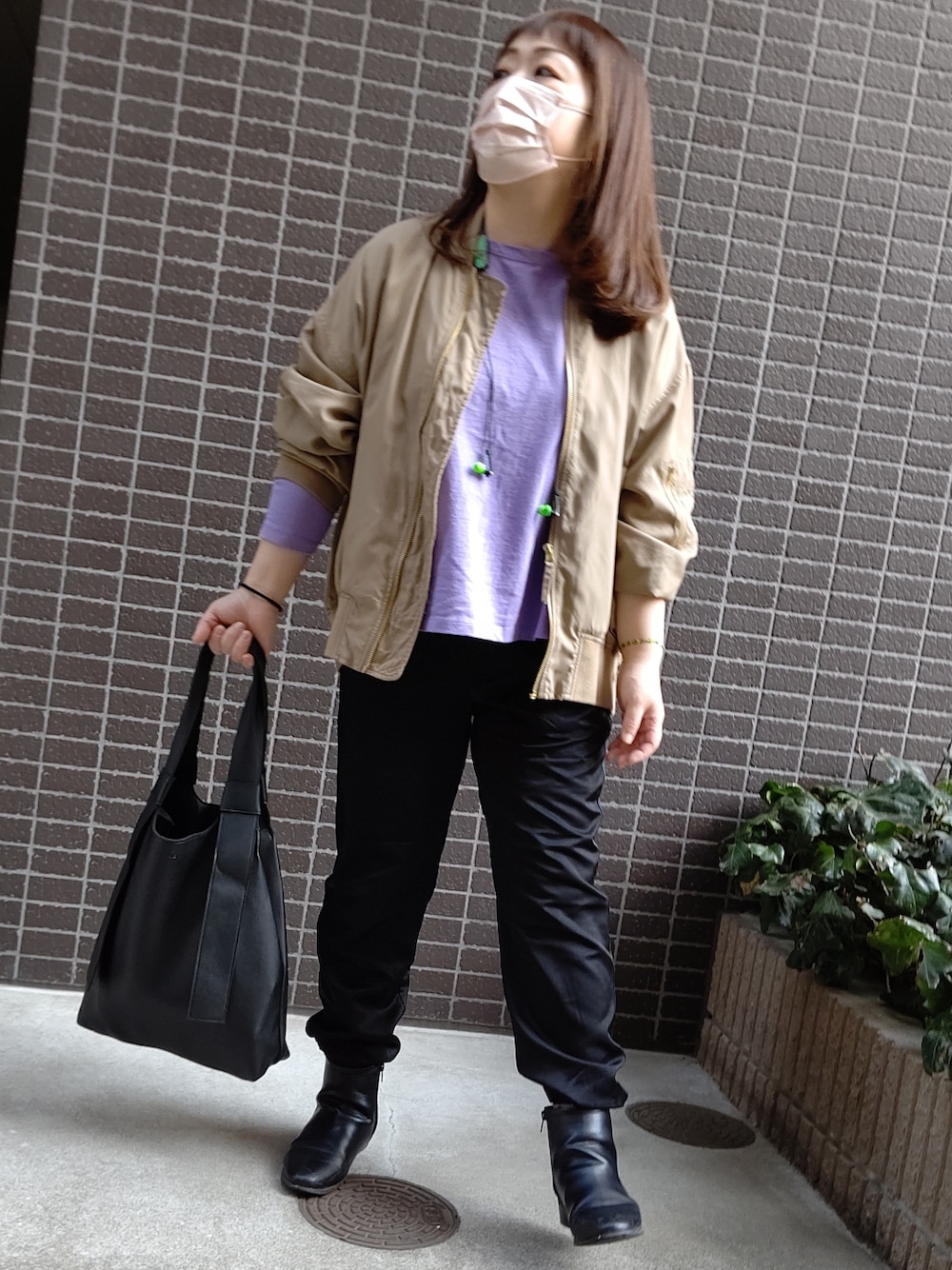 パープル系のTシャツ/カットソー、ブラック系のバッグ、ベージュ系のMA-1を着用したレディースの春コーディネートの3枚目の写真
