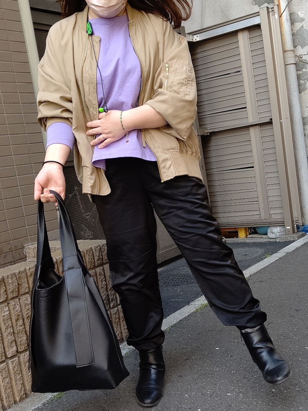 パープル系のTシャツ/カットソー、ブラック系のバッグ、ベージュ系のMA-1を着用したレディースの春コーディネートの2枚目の写真