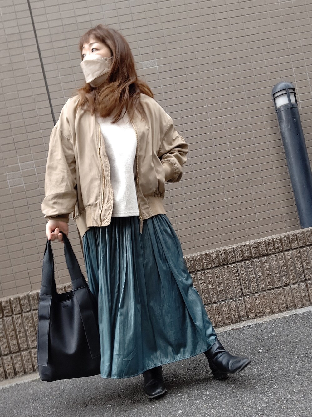 ベージュ系のMA-1、ホワイト系のTシャツ/カットソー、グリーン系のスカートを着用したレディースの春コーディネートの2枚目の写真