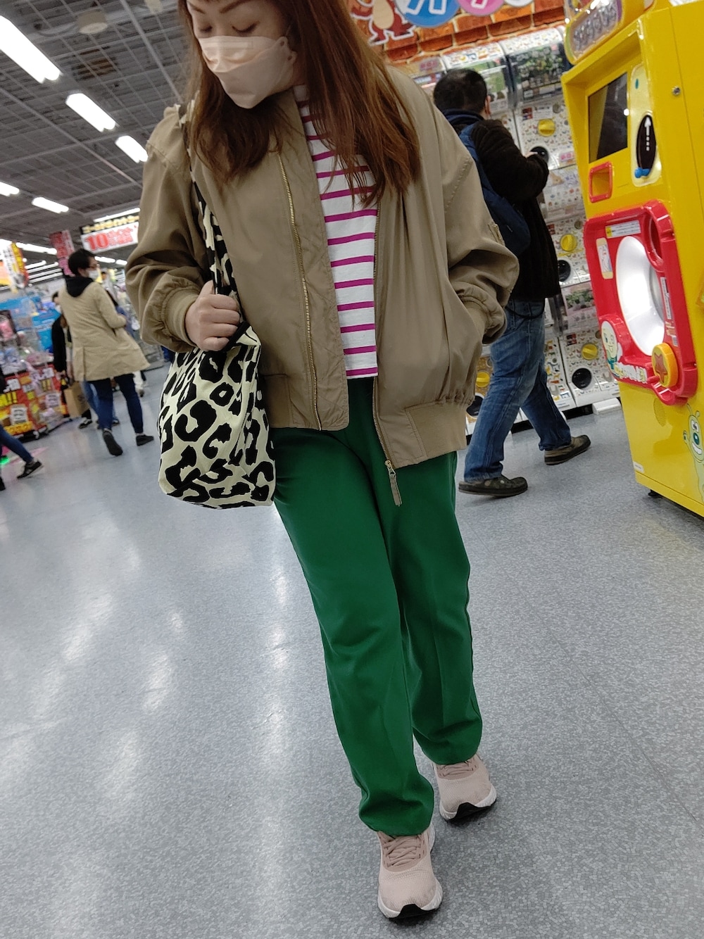 グリーン系のスラックス、ピンク系のスニーカー、ベージュ系のMA-1を着用したレディースの冬コーディネートの2枚目の写真