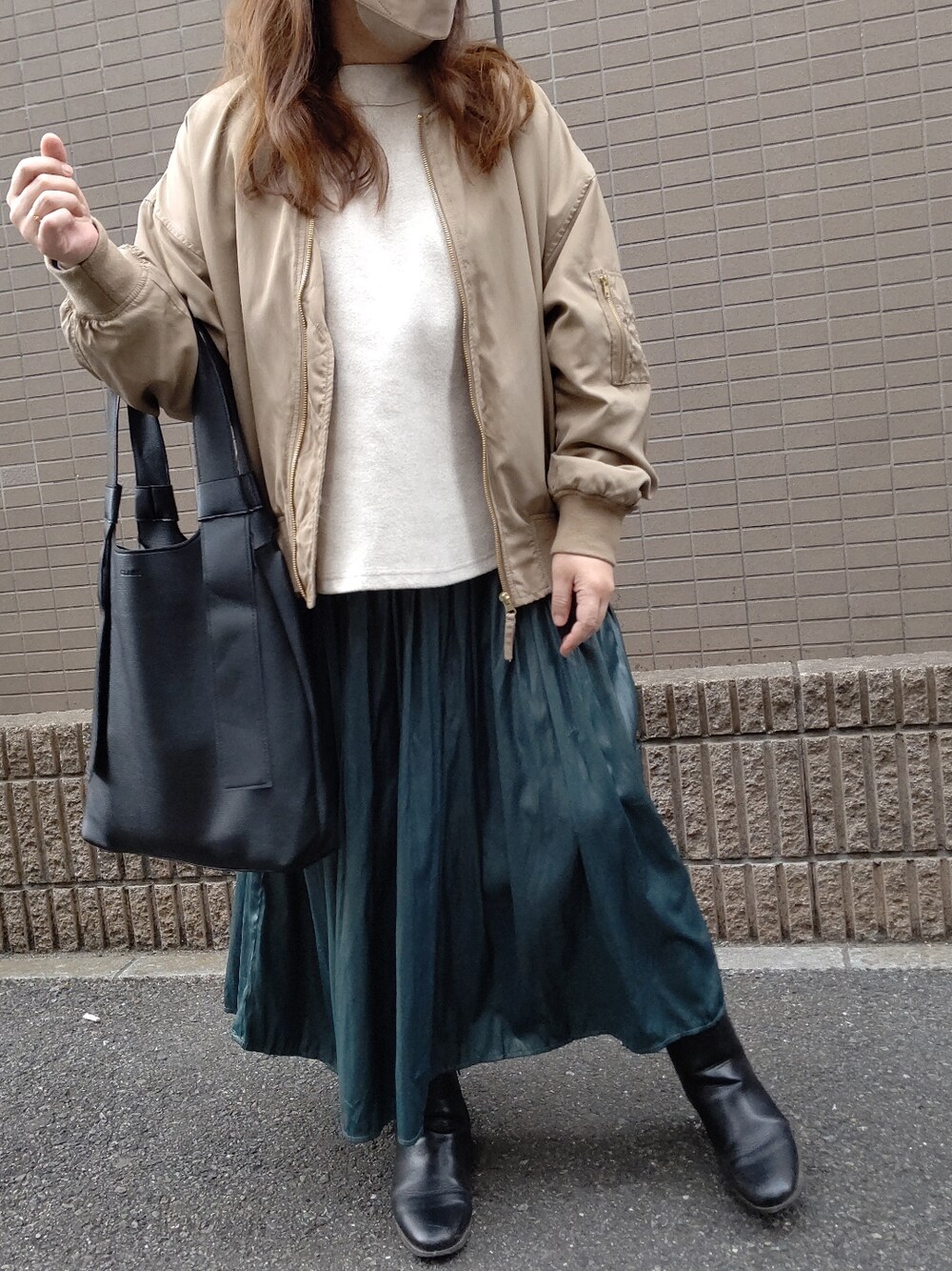 ベージュ系のMA-1、ホワイト系のTシャツ/カットソー、グリーン系のスカートを着用したレディースの春コーディネートの3枚目の写真
