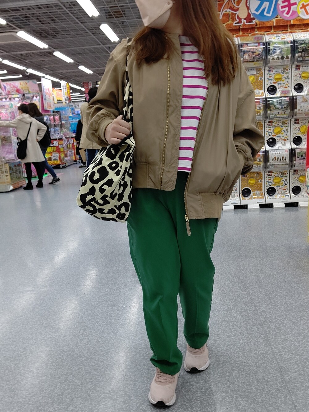 グリーン系のスラックス、ピンク系のスニーカー、ベージュ系のMA-1を着用したレディースの冬コーディネートの3枚目の写真