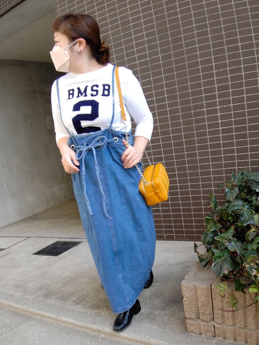 ブルー系のオールインワン・サロペット、ブルー系のTシャツ/カットソー、イエロー系のショルダーバッグを着用したレディースの冬コーディネートの2枚目の写真
