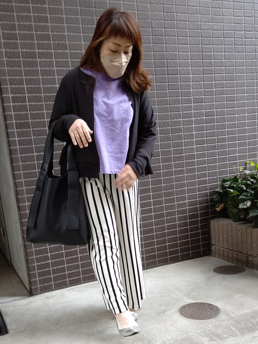 ブラック系のバッグ、シルバー系のパンプス、パープル系のTシャツ/カットソーを着用したレディースの春コーディネートの2枚目の写真