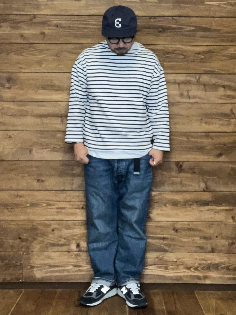 ホワイト系のTシャツ/カットソー、ブルー系のスニーカー、ブルー系のデニムパンツを着用したメンズの春コーディネートの1枚目の写真