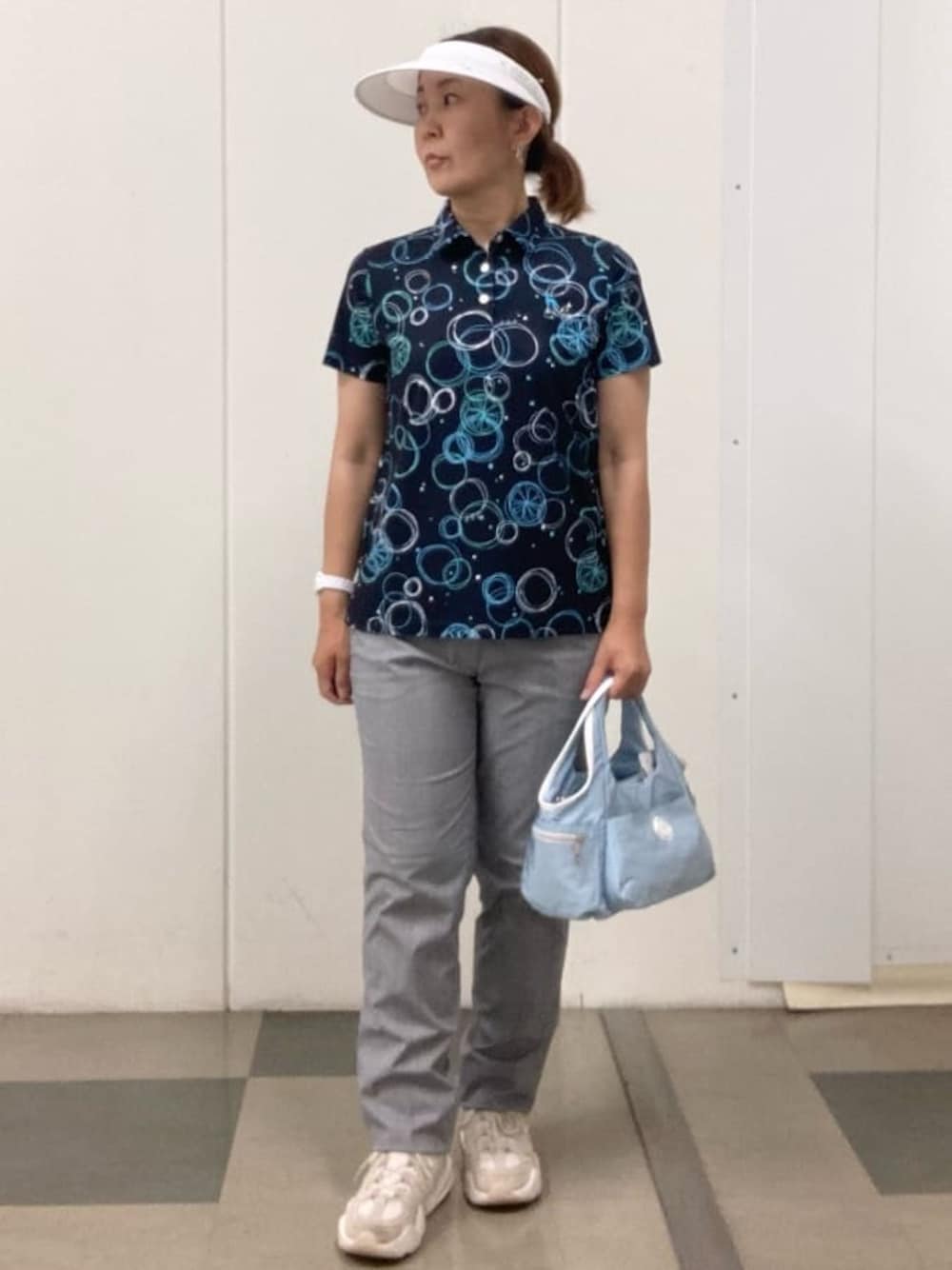 ホワイト系のその他パンツ、ブルー系のポロシャツ、ブルー系のショルダーバッグを着用したレディースの春コーディネートの1枚目の写真