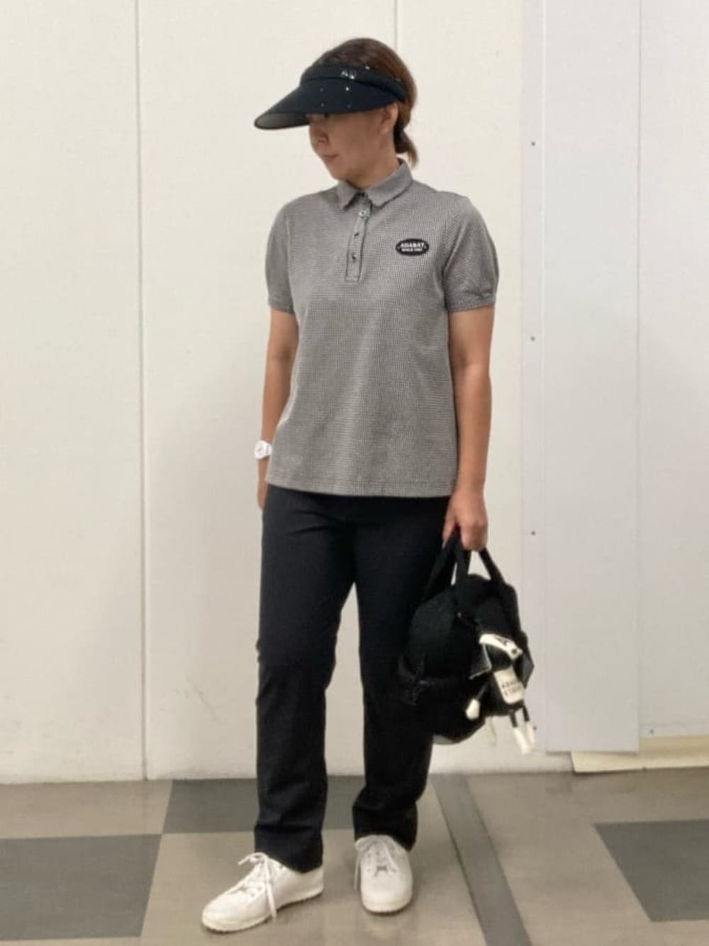 ブラック系のポロシャツ、ブラック系のその他パンツ、ブラック系のハンドバッグを着用したレディースの夏コーディネートの1枚目の写真