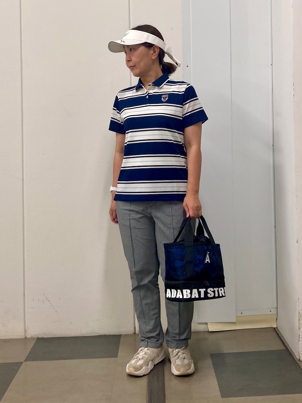 ブラック系のその他パンツ、ブルー系のトートバッグ、ブルー系のポロシャツを着用したレディースの夏コーディネートの1枚目の写真