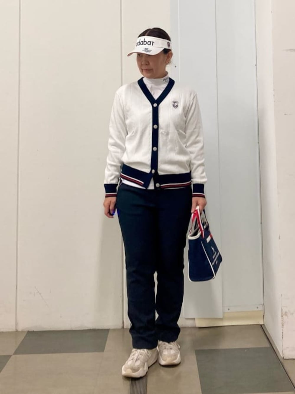 ホワイト系のカーディガン/ボレロ、ホワイト系のTシャツ/カットソー、ブラック系のその他パンツを着用したレディースの冬コーディネートの1枚目の写真