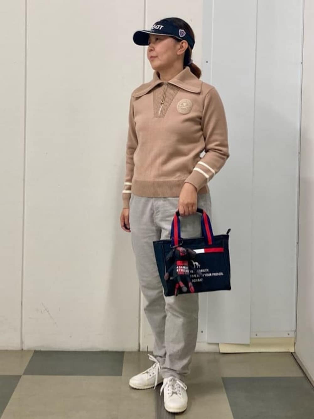 ベージュ系のニット/セーター、グレー系のその他パンツ、ブラック系のトートバッグを着用したレディースの冬コーディネートの1枚目の写真
