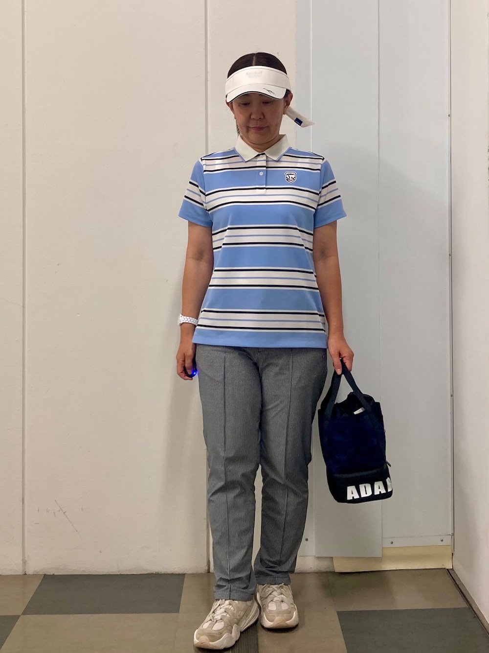 ブルー系のポロシャツ、ブラック系のその他パンツ、ブルー系のトートバッグを着用したレディースの夏コーディネートの1枚目の写真