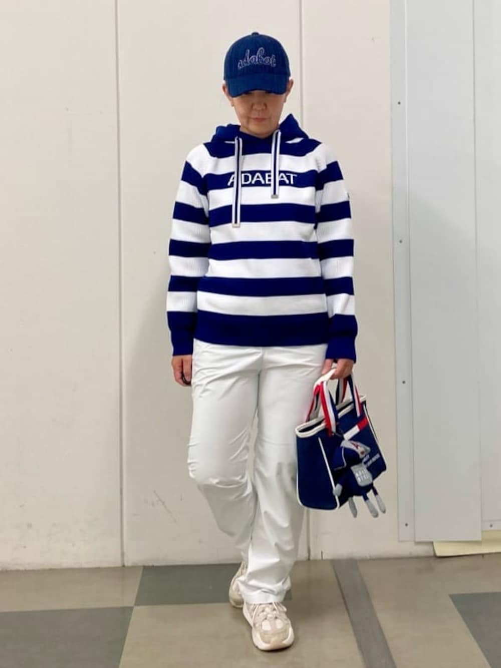ブルー系のニット/セーター、ホワイト系のその他パンツ、グレー系のトートバッグを着用したレディースの秋コーディネートの1枚目の写真