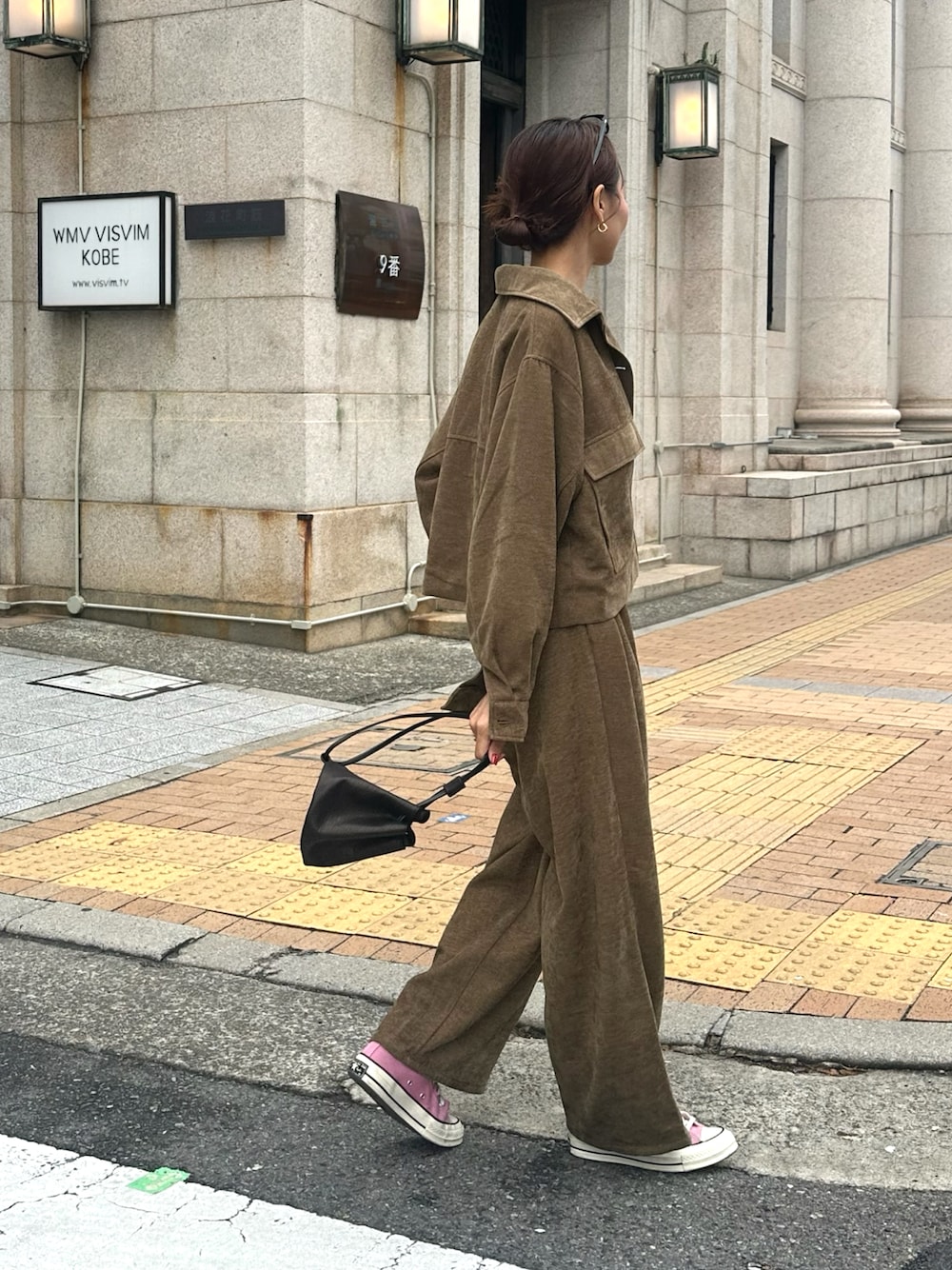 ブラウン系のパンツ、ブラック系のショルダーバッグ、ブラウン系のミリタリージャケットを着用したレディースの秋コーディネートの1枚目の写真