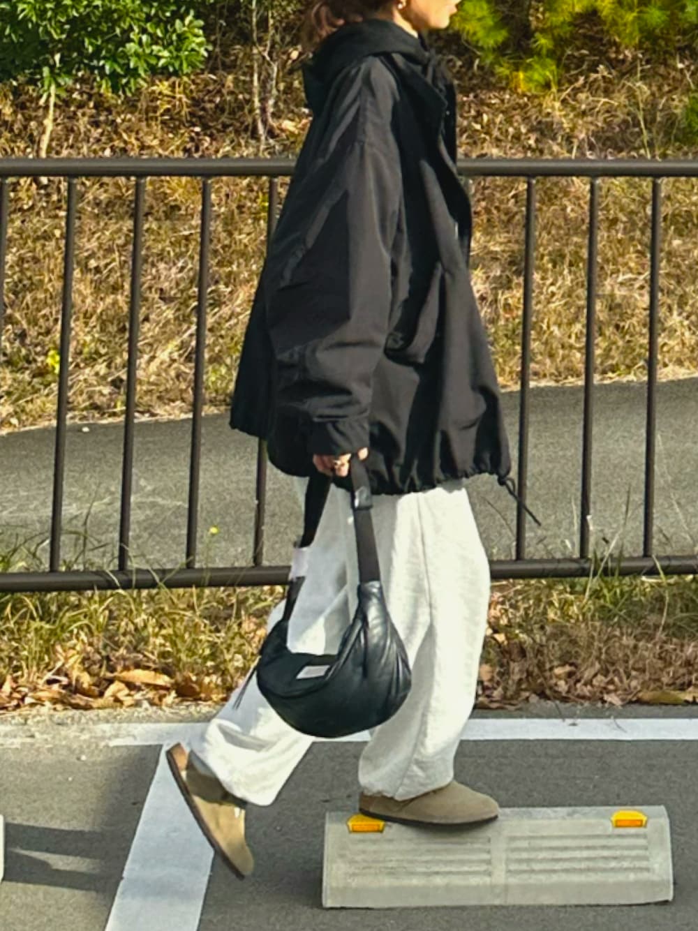 ブラック系のモッズコート、ベージュ系のサンダル、グレー系のスウェットパンツを着用したレディースの冬コーディネートの1枚目の写真