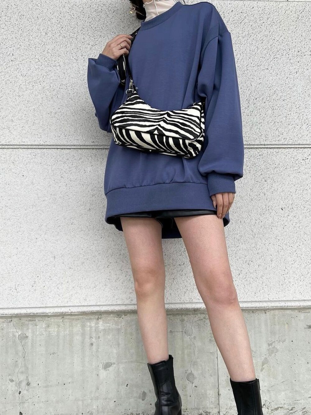 ブラック系のショルダーバッグ、ブルー系のスウェット、ホワイト系のTシャツ/カットソーを着用したレディースの冬コーディネートの1枚目の写真