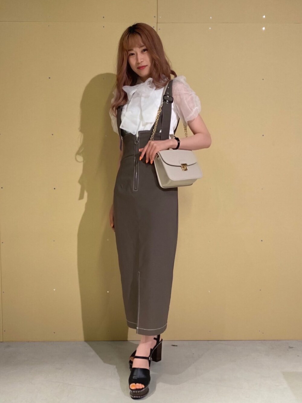 ホワイト系のシャツ/ブラウス、グレー系のスカート、グレー系のショルダーバッグを着用したレディースの夏コーディネートの1枚目の写真