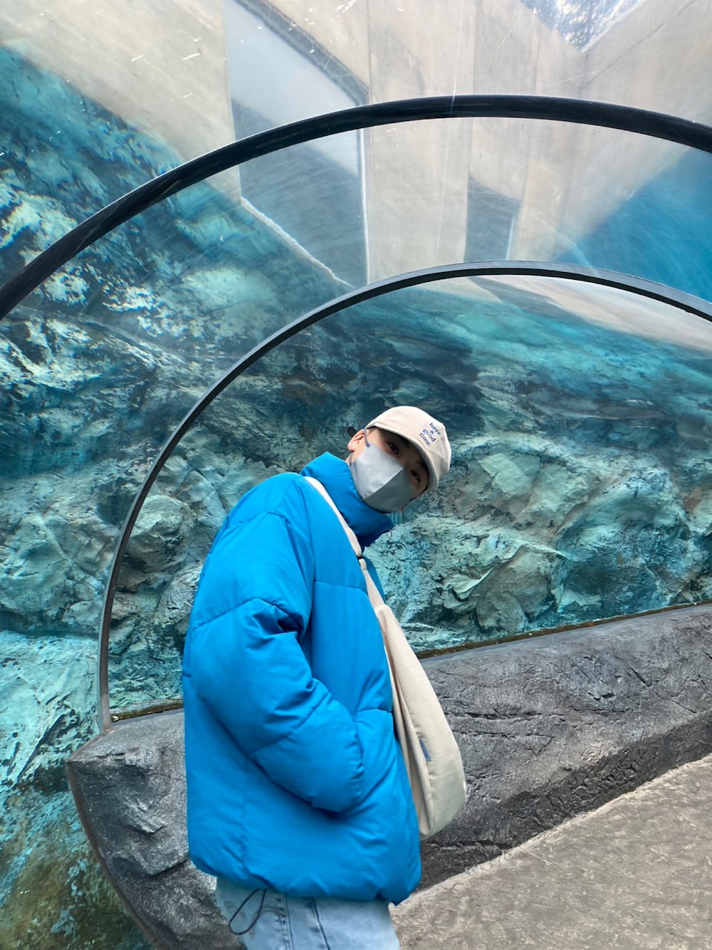 ブラック系のダウンジャケット/コート、ホワイト系のショルダーバッグ、ブルー系のデニムパンツを着用したメンズの冬コーディネートの1枚目の写真