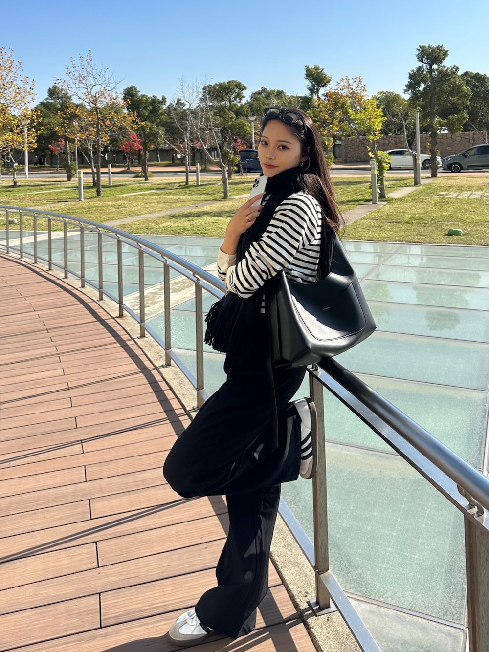 ブラック系のニット/セーター、ブラック系のショルダーバッグ、ブラック系のスラックスを着用したレディースの秋コーディネートの1枚目の写真