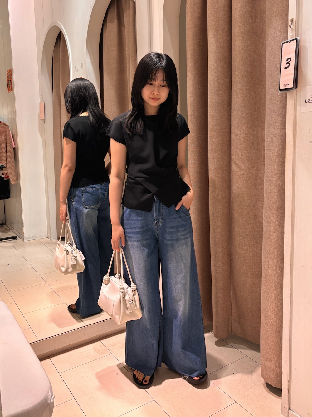 ブルー系のデニムパンツ、ブラック系のサンダルを着用したレディースの夏コーディネートの1枚目の写真