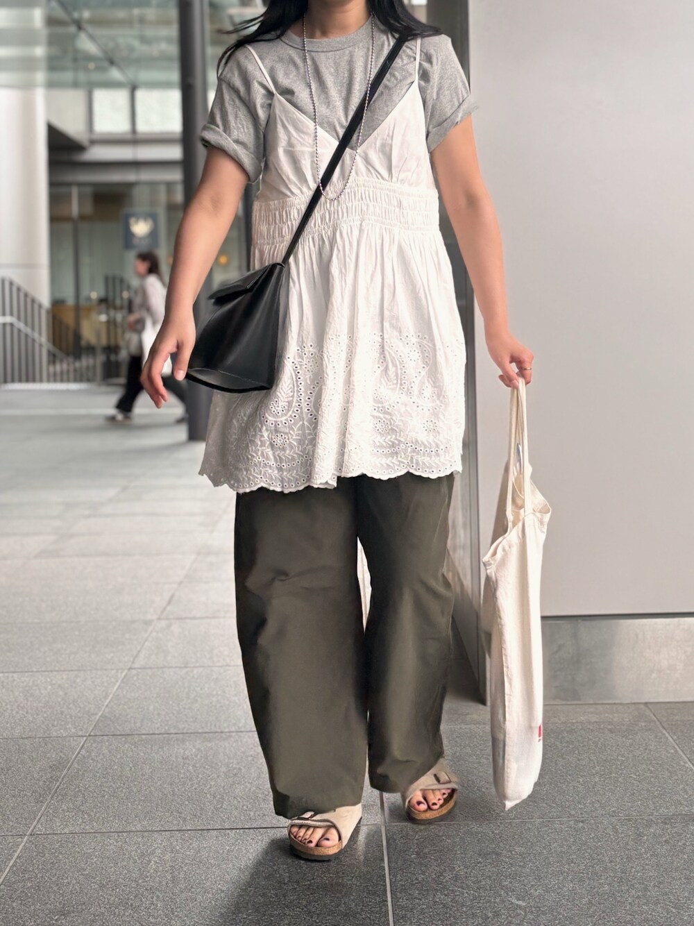 ホワイト系のトートバッグ、ベージュ系のサンダル、ブラック系のショルダーバッグを着用したレディースの春コーディネートの1枚目の写真