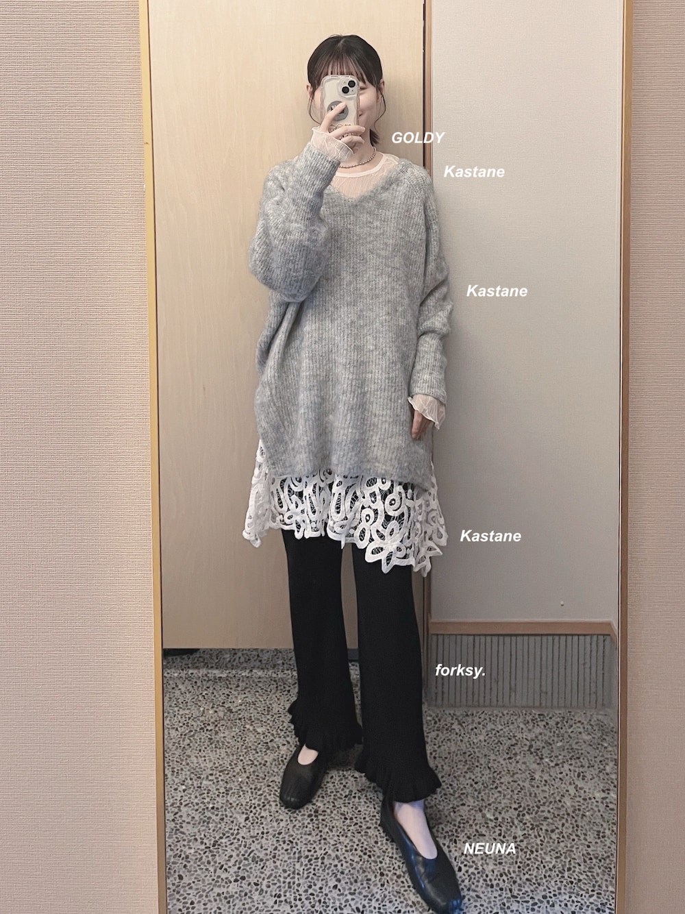 グレー系のニット/セーター、ホワイト系のチュニック、ブラック系のその他パンツを着用したレディースの冬コーディネートの1枚目の写真