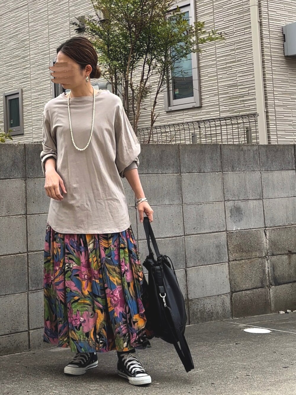 グリーン系のTシャツ/カットソー、ブラック系のショルダーバッグ、ブラック系のスニーカーを着用したレディースの春コーディネートの1枚目の写真