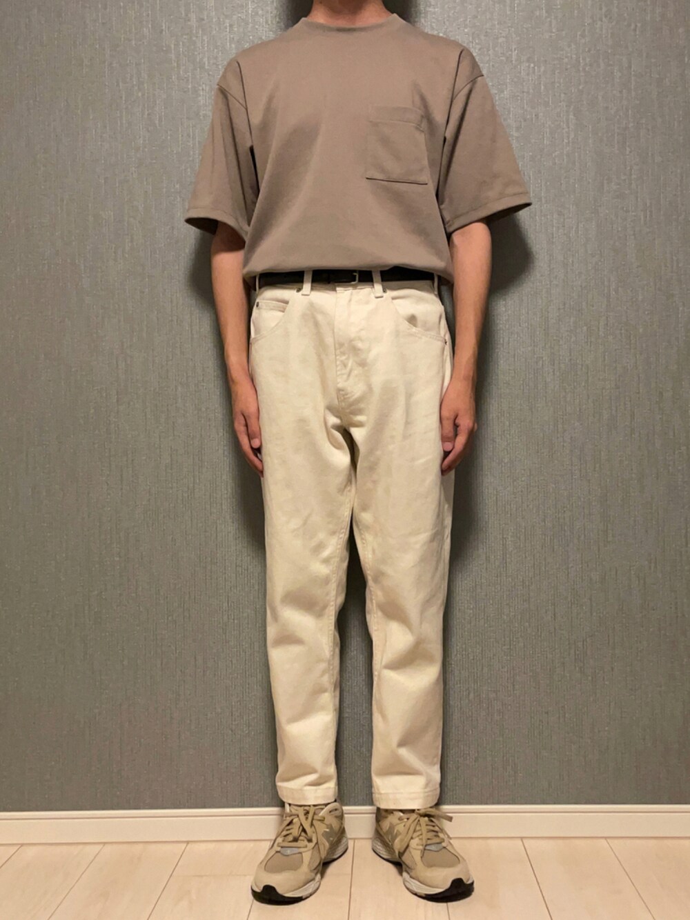 ベージュ系のTシャツ/カットソー、ホワイト系のデニムパンツ、グレー系のスニーカーを着用したメンズの秋コーディネートの1枚目の写真