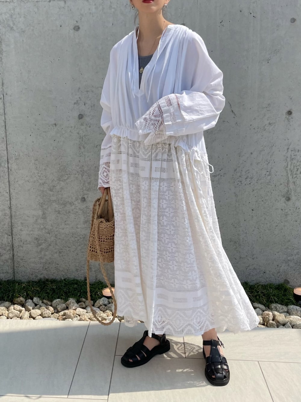 ホワイト系のワンピース、ブラック系のサンダルを着用したレディースの夏コーディネートの1枚目の写真