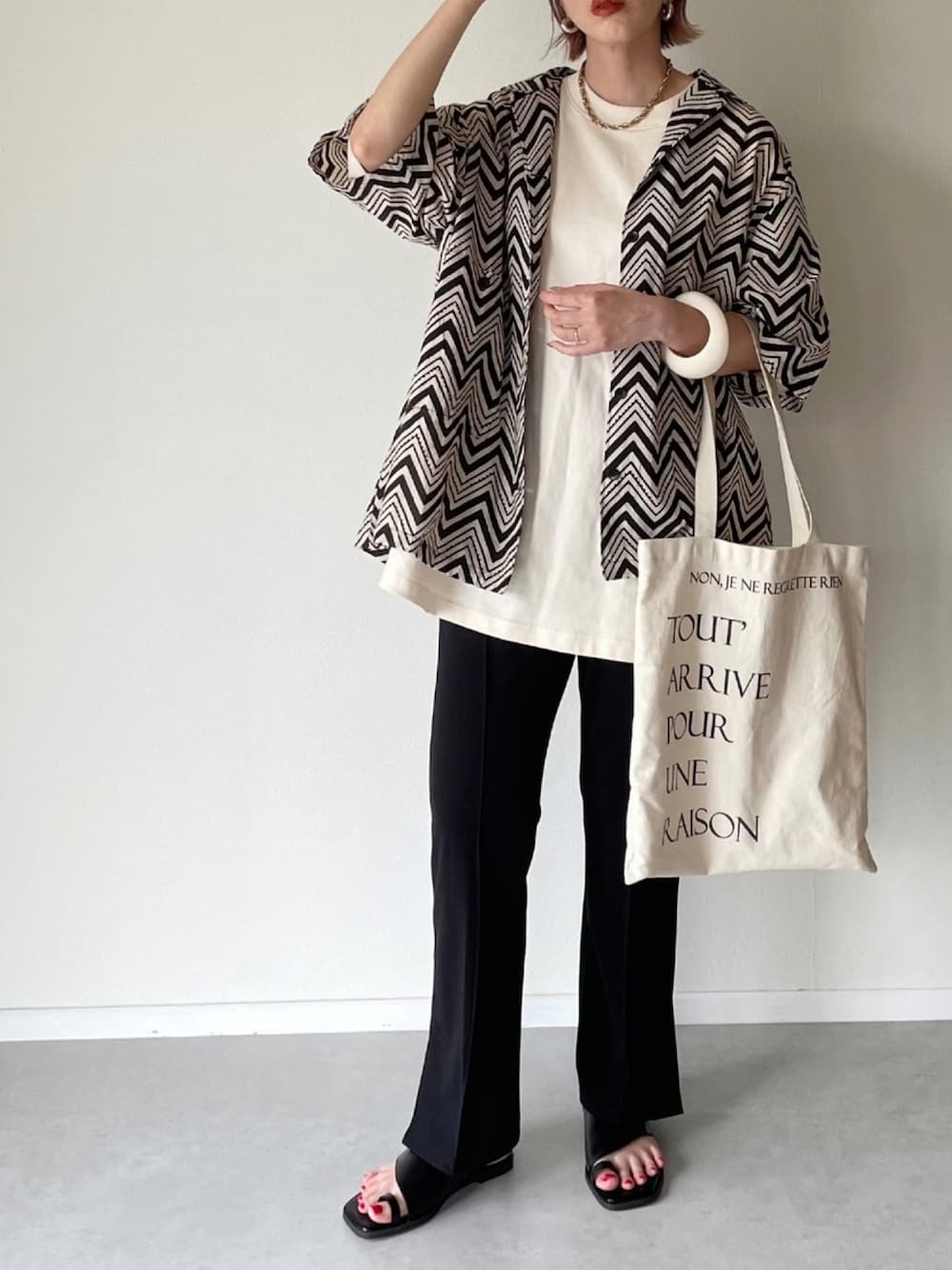 ブラック系のスラックス、ブラック系のシャツ/ブラウス、ブラック系のサンダルを着用したレディースの夏コーディネートの1枚目の写真