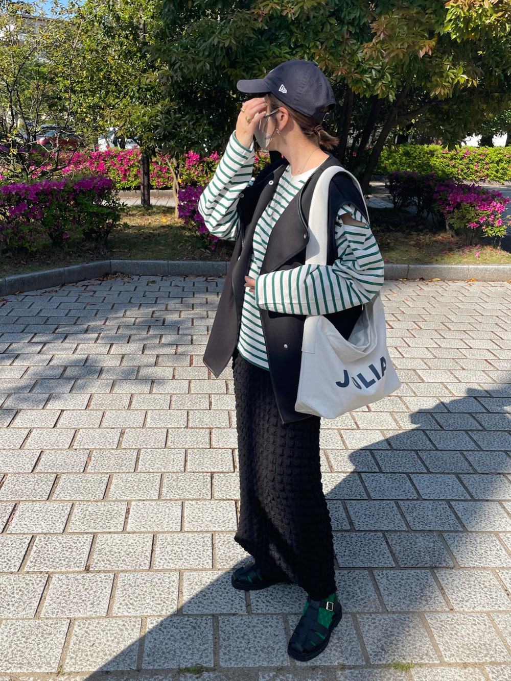 ブラック系のその他シューズ、ブラック系のスカート、ブラック系のベストを着用したレディースの春コーディネートの1枚目の写真