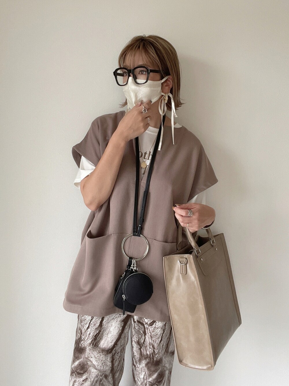 ベージュ系のトートバッグ、ブラウン系のその他パンツ、ホワイト系のTシャツ/カットソーを着用したレディースの夏コーディネートの1枚目の写真