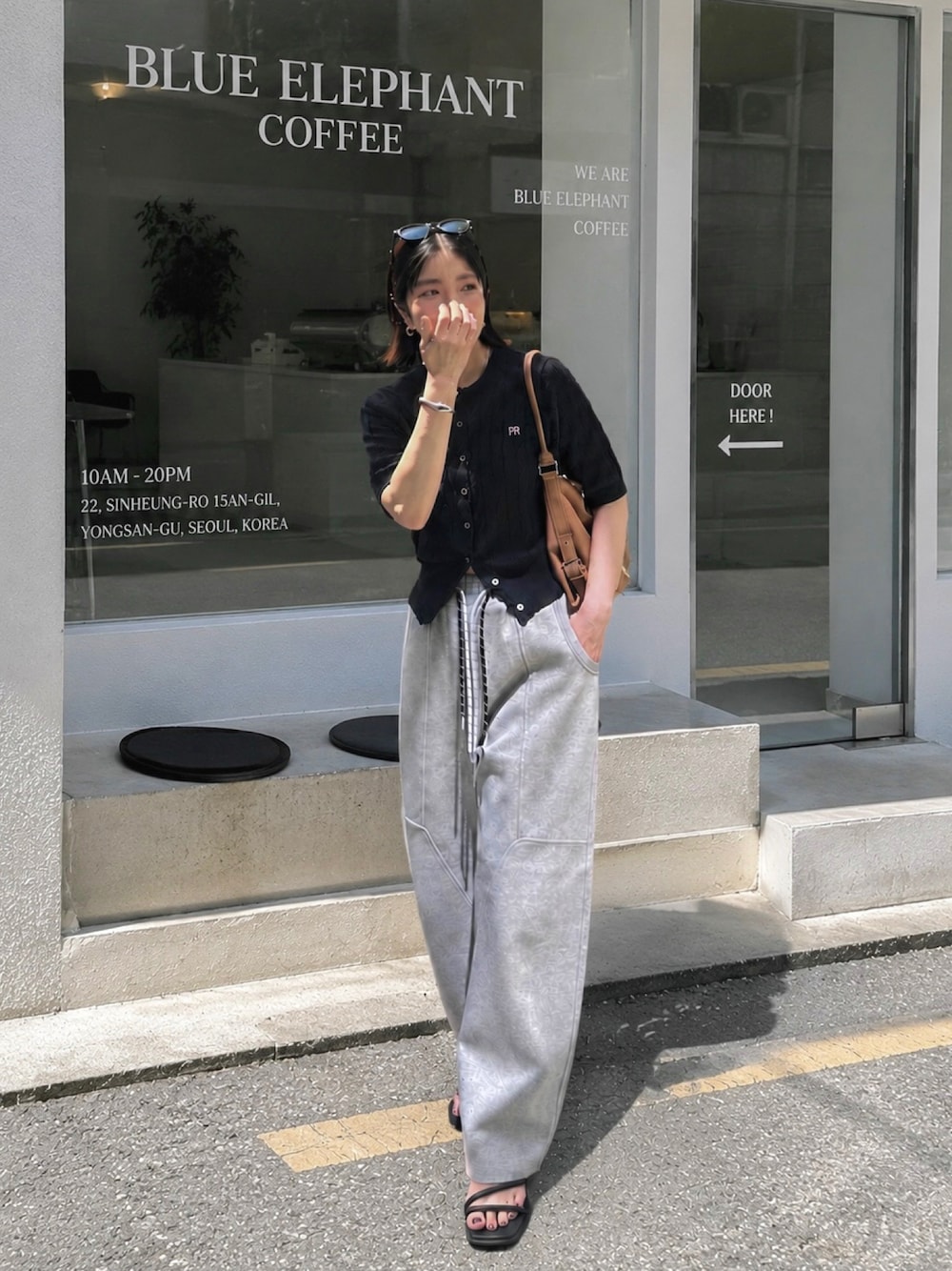 ブルー系のカーディガン/ボレロ、グレー系のスウェットパンツ、イエロー系のショルダーバッグを着用したレディースの夏コーディネートの1枚目の写真