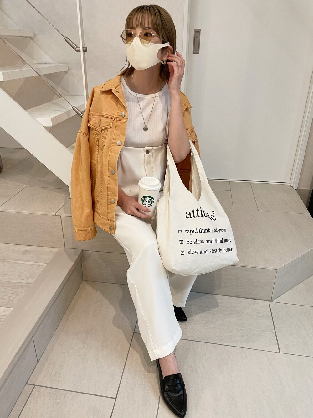 オレンジ系のデニムジャケット、ブラック系のローファー、ホワイト系のサロペット/オーバーオールを着用したレディースの春コーディネートの1枚目の写真