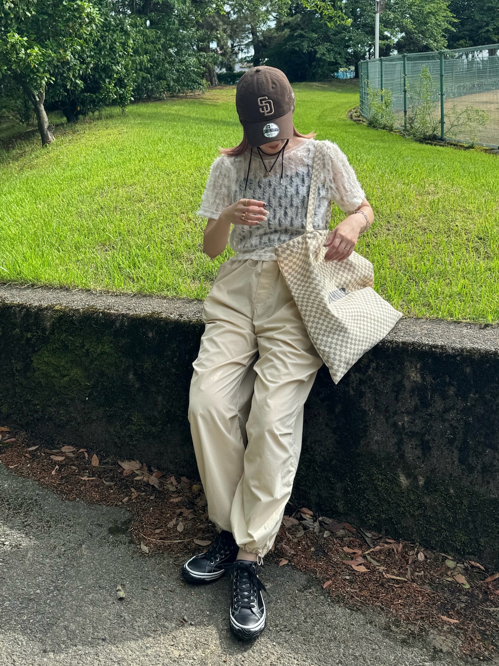 ブラック系のスニーカー、ホワイト系のTシャツ/カットソー、ベージュ系のトートバッグを着用したレディースの春コーディネートの1枚目の写真