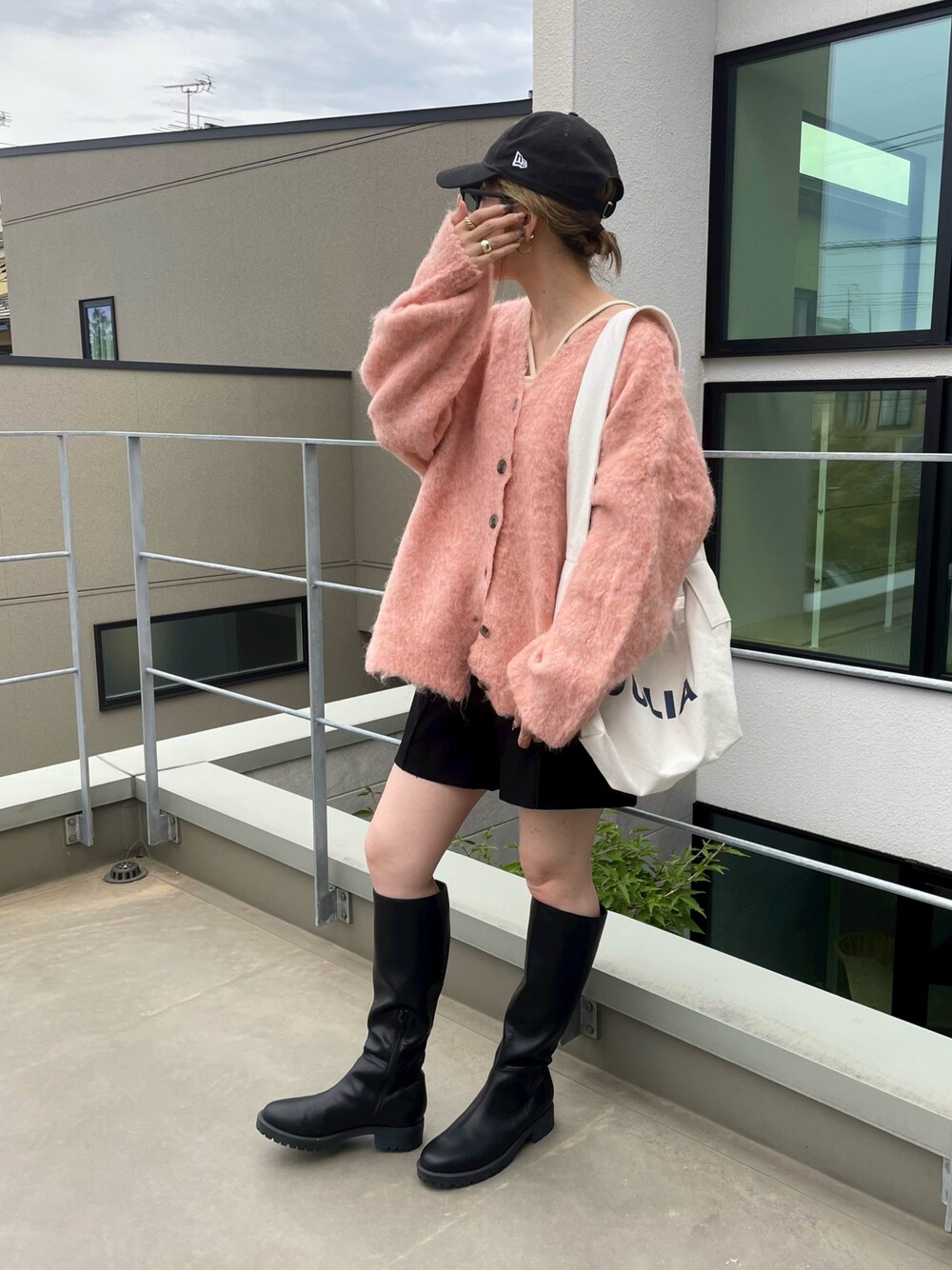 オレンジ系のニット/セーター、ブラック系のその他パンツ、ホワイト系のキャミソールを着用したレディースの秋コーディネートの1枚目の写真