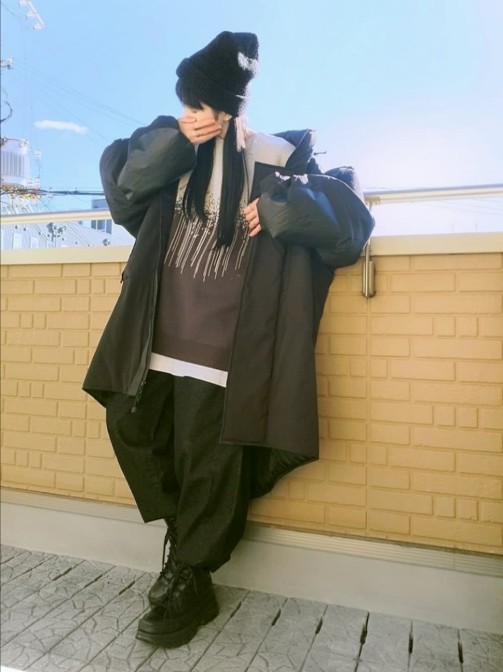 ブラック系のスニーカー、グレー系のデニムパンツ、ブラック系のミリタリージャケットを着用したレディースの冬コーディネートの1枚目の写真