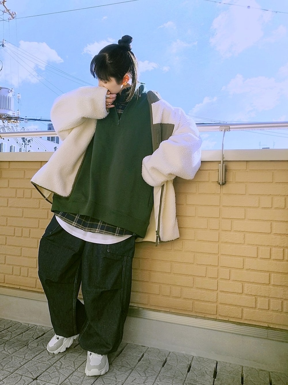 ブルー系のデニムパンツ、グレー系のスニーカー、グリーン系のスウェットを着用したレディースの冬コーディネートの1枚目の写真