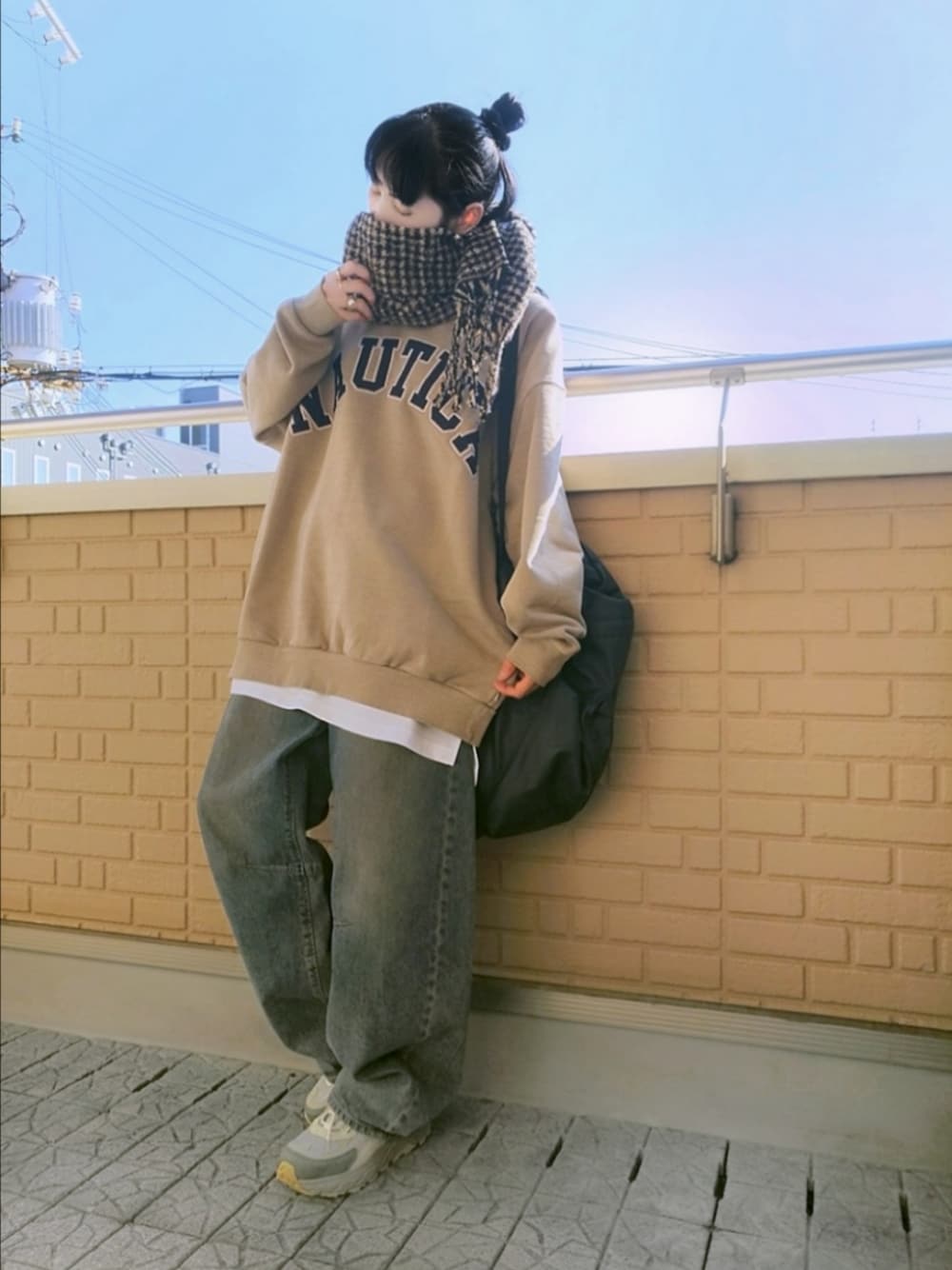 ベージュ系のスニーカー、ブルー系のデニムパンツ、ベージュ系のスウェットを着用したレディースの秋コーディネートの1枚目の写真