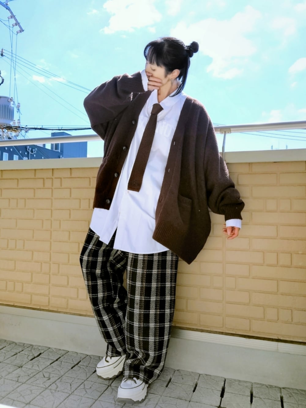 ホワイト系のスニーカー、ブラック系のその他パンツ、ブラウン系のニット/セーターを着用したレディースの秋コーディネートの1枚目の写真