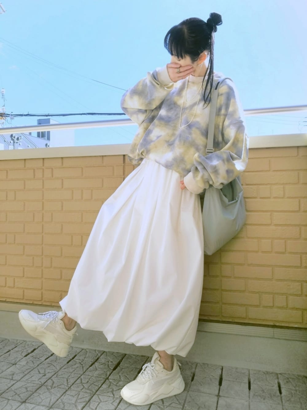 ホワイト系のスニーカー、ホワイト系のスカート、グレー系のショルダーバッグを着用したレディースの春コーディネートの1枚目の写真