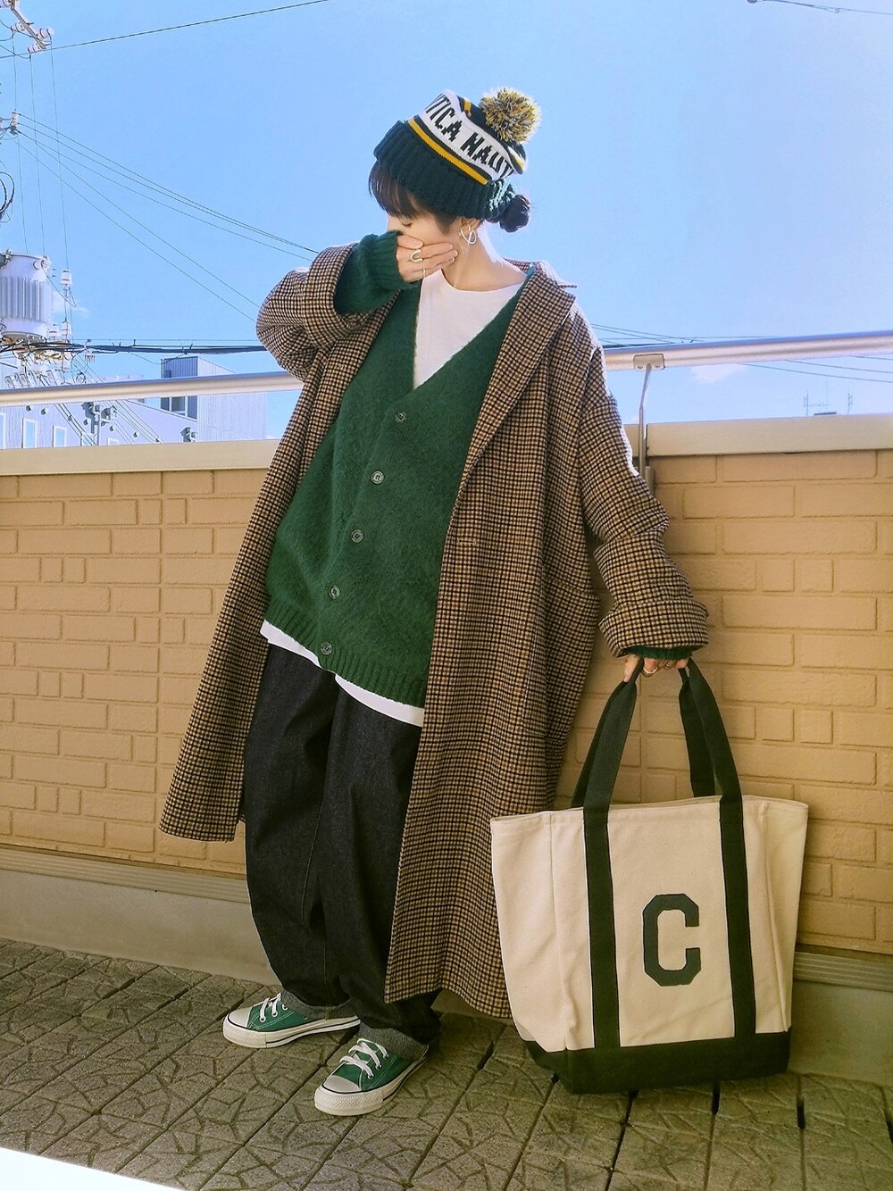 グリーン系のカーディガン/ボレロ、ベージュ系のチェスターコート、グリーン系のトートバッグを着用したレディースの冬コーディネートの1枚目の写真