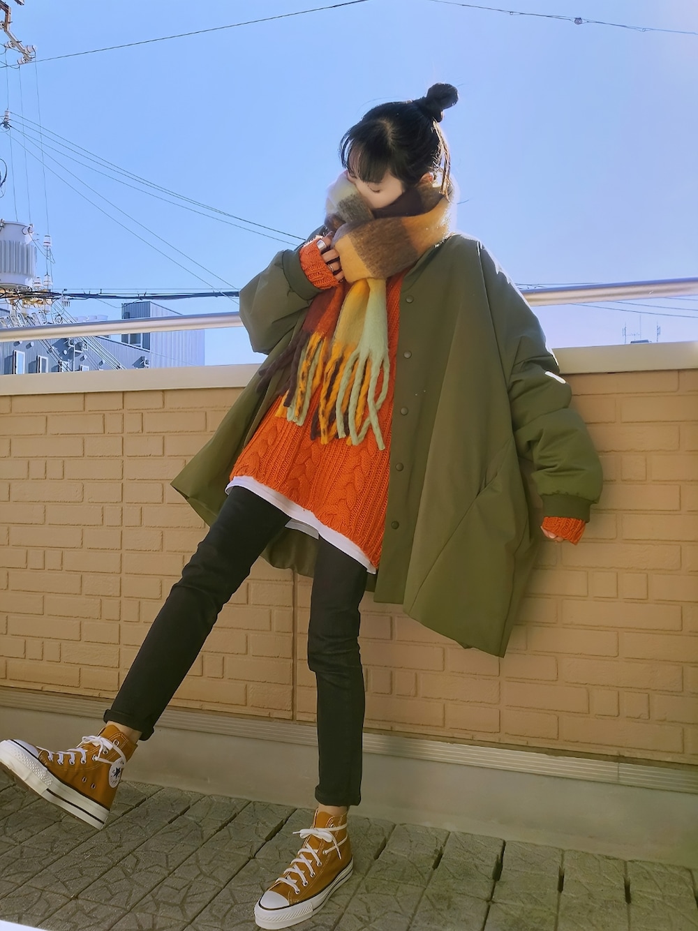 グリーン系のMA-1、オレンジ系のニット/セーター、ブラック系のデニムパンツを着用したレディースの冬コーディネートの1枚目の写真