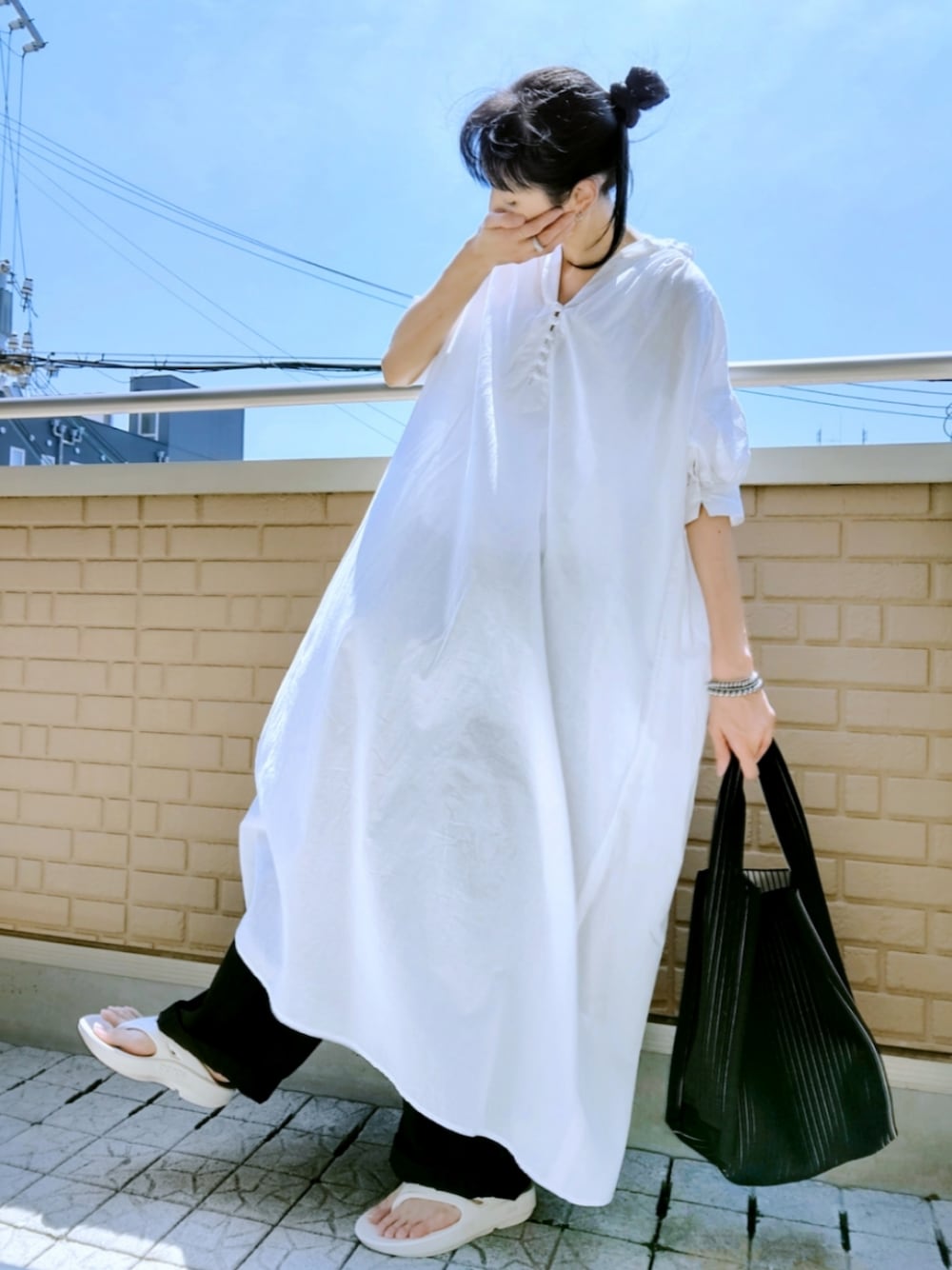 ベージュ系のサンダル、ブラック系のその他パンツ、ホワイト系のワンピースを着用したレディースの夏コーディネートの1枚目の写真