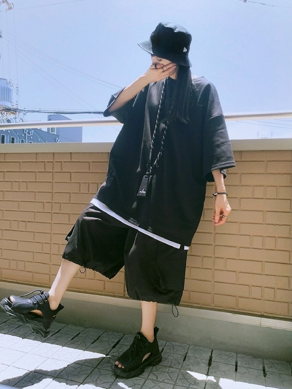 ブラック系のサンダル、ブラック系のカーゴパンツ、ブラック系のTシャツ/カットソーを着用したレディースの夏コーディネートの1枚目の写真