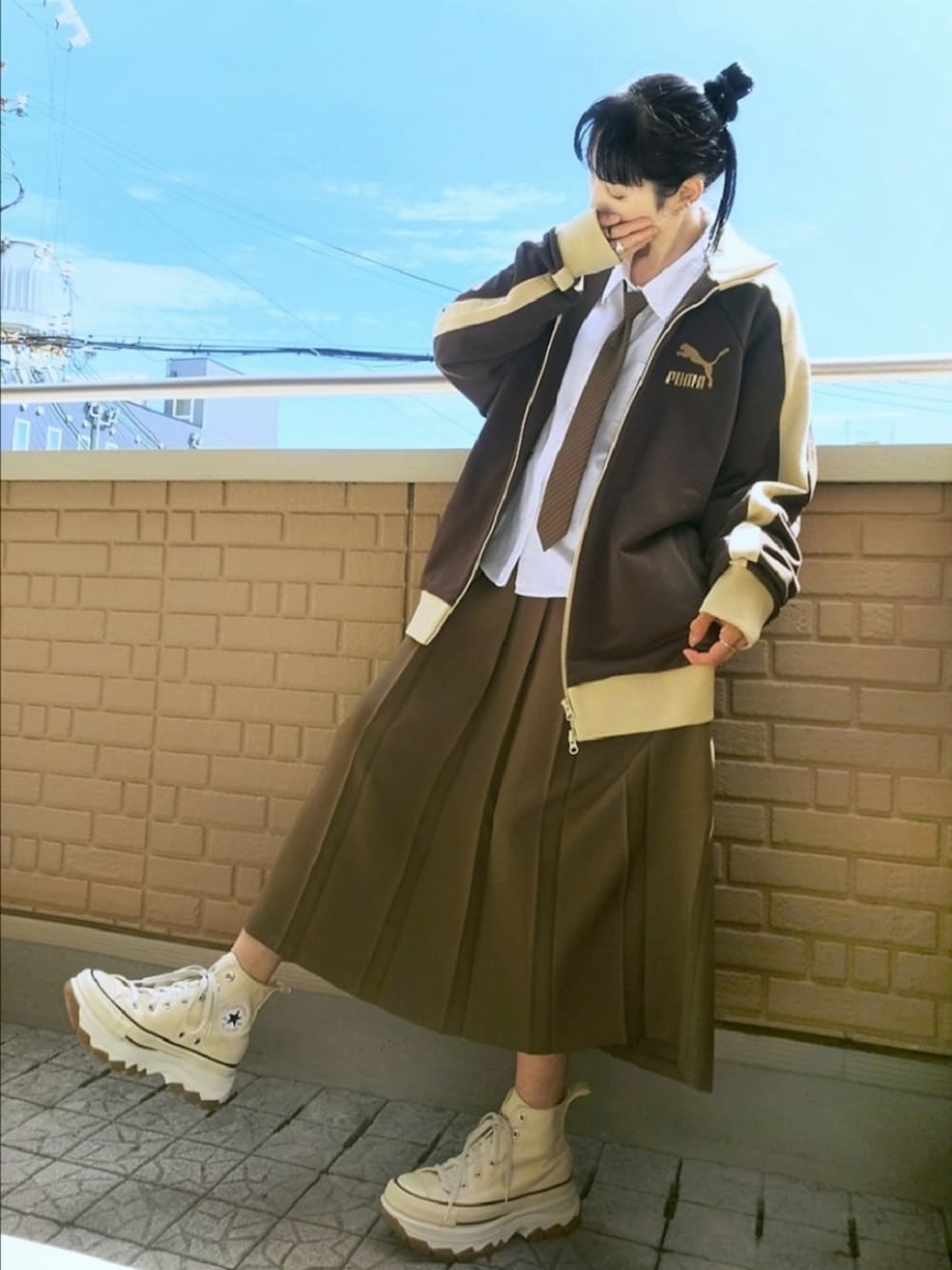 ホワイト系のスニーカー、ブラウン系のスカート、ブラウン系のジャージを着用したレディースの秋コーディネートの1枚目の写真